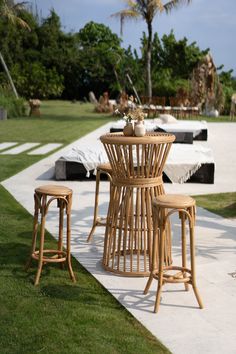 an outdoor table and stools on the grass