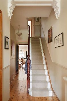 the stairs in this house are made of wood and have white carpeting on them