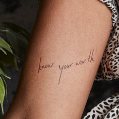 a woman's arm with the words know your worth tattooed on her left arm