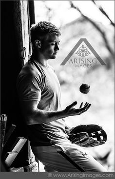 a man sitting on a window sill holding a ball and glove