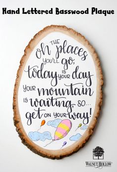 a wood slice with the words on it and an image of a hot air balloon