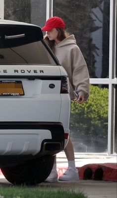 the woman is stepping out of her white range rover