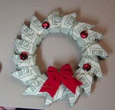 a christmas wreath made out of dollar bills with a red bow on the front and side