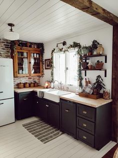 the kitchen is decorated in black and white with wood trimmings on the walls