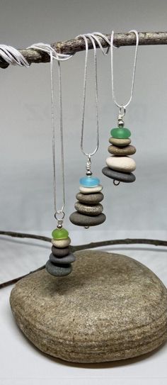 "We've paired our popular Cairn pendant with summery beach glass to create one of a kind statement pieces! Each pendant is truly unique; although each pendant's smooth glass and rocks are similar in size, the colors of each will vary and each is beautiful in its own way. I take care in selecting the placement of each stone in the stack. The pendant is made with smooth lake stones (sourced in Ohio), beach glass, and are chased with plated silver wire. A complimentary 24\" plated silver necklace i Diy Rock Jewelry, Cairn Necklace, Jewelry Making Pearls, Rock Pendant, Beach Stones Jewelry, Pebble Jewelry, Necklace Minimalist Jewelry, Rock Necklace, Art Jewelry Contemporary