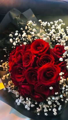 a bouquet of red roses and baby's breath