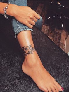 a woman's foot with a flower tattoo on it