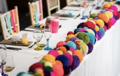 the table is decorated with colorful pom - poms