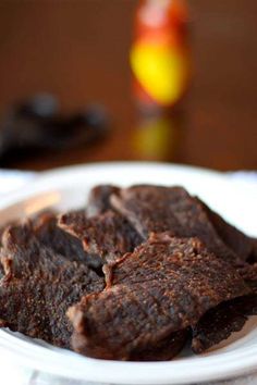 some brownies on a white plate sitting on a table