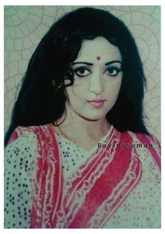 an old photo of a woman with long black hair wearing a red and white scarf