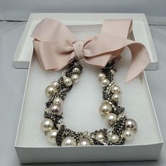 a box with some pearls and a pink bow on it