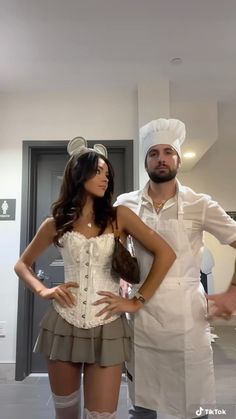 a man and woman dressed up as chefs standing next to each other in the kitchen