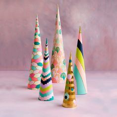 several colorful cones are lined up on a table with a pink wall in the background