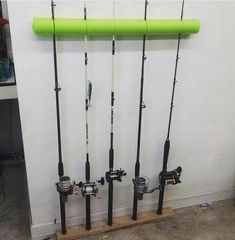 several fishing rods are lined up against the wall