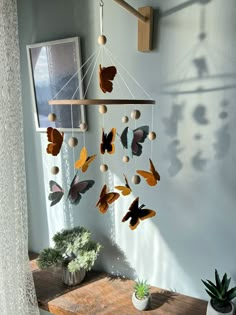 a wooden table topped with a mobile filled with butterflies