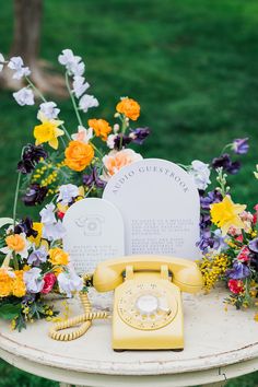 Yellow phone surrounded by colorful flowers Wedding Phone Booth, After The Tone, Wedding Welcome Table, Wedding Phone, Wedding Pastel, Wedding Guest Book Table, Wedding Guest Table, Barr Mansion, Audio Guest Book