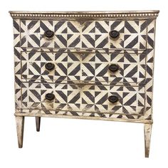 an old dresser with geometric designs on the top and bottom, painted in black and white