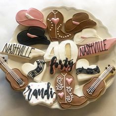 decorated cookies are arranged in the shape of hats, guitars, and other items on a plate