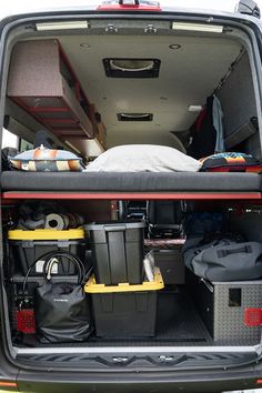 the back end of a van with luggage and other items in it's trunk