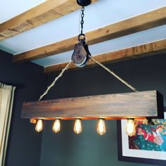 a light fixture hanging from the ceiling in a room with blue walls and wood beams