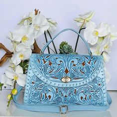 Forget love, fall in leather! ♡ -Zarota is a beautifully chiseled floral handbag that is eye-catching and distinctive. It not only features a luxurious baby blue made with 100% genuine leather exterior and a suede lining interior, but also gleaming gold hardware such as its lock and zippers. Truly, Zarota is a rare, one-of-a-kind, handcrafted daily bag that will last you an eternity.  -100% handmade with zero mechanical equipment used; Zarota is made within 3-5 days and is painted and chiseled precisely with love and care! Includes: -LxWxH: 14x4x9 -Dust Bag -It is important to note that handmade artisanal leather products may contain minor imperfections, which is 100% normal.  Please send me a message if you have any concerns. Have a beautiful day! ♡ Tooled Leather Bag, Tooled Leather Purse, Diy Leather Bag, Floral Handbags, Daily Bag, Bags Handmade, Hand Tooled Leather, Leather Bags Handmade, Artisan Design