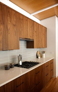 a kitchen with wooden cabinets and white counter tops