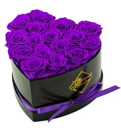 a heart shaped box filled with purple roses