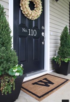 the front door is decorated with wreaths and potted trees for sale on instagram