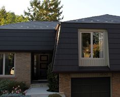 a house with a black roof and two windows