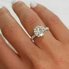 a woman's hand with a diamond ring on her finger and an engagement band