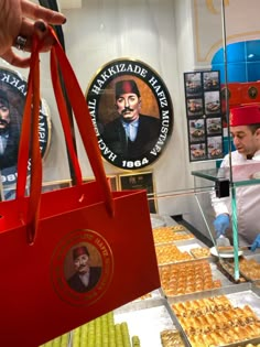 a person holding a red shopping bag in front of some pastries and cornbreads