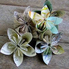 several origami flowers sitting on top of a wooden table