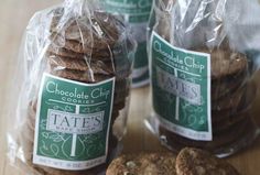 chocolate chip cookies are wrapped in plastic and sitting on a table next to each other