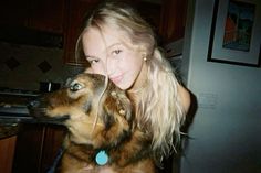 a woman is hugging her dog in the kitchen