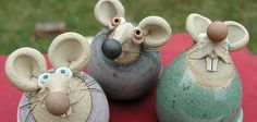 three ceramic mouses sitting on top of a red cloth covered table next to each other