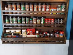 a wooden spice rack filled with lots of spices