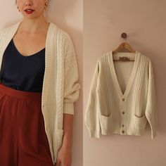 Unisex, Italian 90s vintage cardigan in cream white. A smooth, extra-soft garment for easy layering. It features a deep V neckline and a delicate mix of rib and cable knit design. Slightly stretchy. Medium to heavy weight with a boxy fit. Front pockets. Long sleeves. Long length. Gold toned button-up fastening. MATERIAL: 50% wool, 50% acrylic BRAND: Sealine by Settebello, made in Italy  **CONDITION: Excellent Vintage Condition **MEASUREMENTS: UK 22 / US 18 / EU 50 Our model's size is UK 10, US 6 Oversized Cream Cardigan For Everyday, Classic Oversized Cream Cardigan, Oversized Classic Cream Cardigan, Oversized Vintage Cream Sweater, White Cotton Retro Cardigan, White Vintage Knitted Cardigan, Oversized Vintage V-neck Cardigan, Vintage White Cardigan With Buttons, Vintage Cream Cable Knit Cardigan