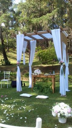 an outdoor wedding setup with white drapes and flowers