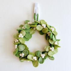 a green and white wreath hanging on the wall