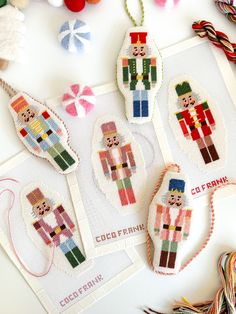 cross stitch ornaments are displayed on a table