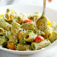 a bowl filled with pasta and vegetables on top of a table