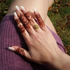 a woman's hand with henna tattoos on it