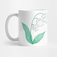 a white coffee mug with three little lambs on it's side and green leaves