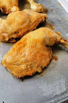 two pieces of chicken sitting on top of a pan