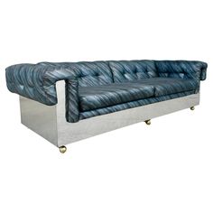 a blue and silver couch sitting on top of a metal frame