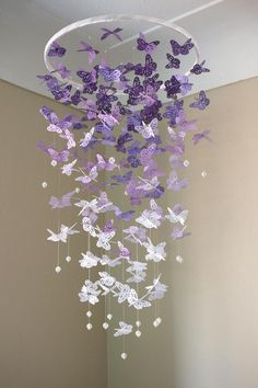 a wind chime with purple and white butterflies hanging from it's centerpiece