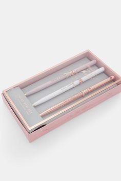 two pens in a pink box on a white surface