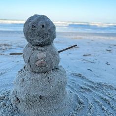 a snowman made out of sand on the beach