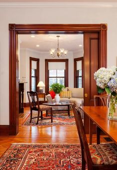 a living room filled with lots of furniture and flowers on top of a wooden table