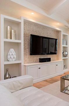 a living room filled with furniture and a flat screen tv mounted on a wall above a fireplace